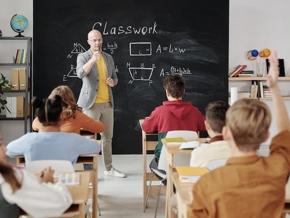 A teacher standing in front of a classroom of young students. 