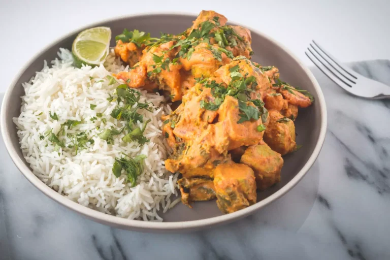A plate of chicken tikka masala and rice.