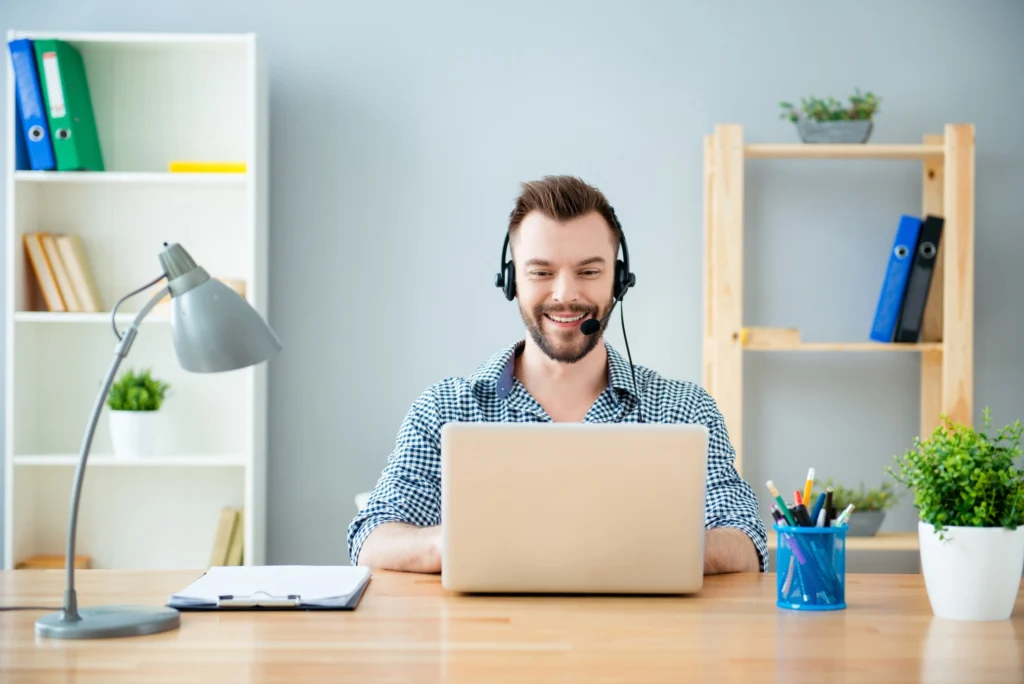 A man smiling and looking at his laptop.