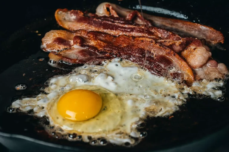 Bacon and eggs cooking in a hot pan.