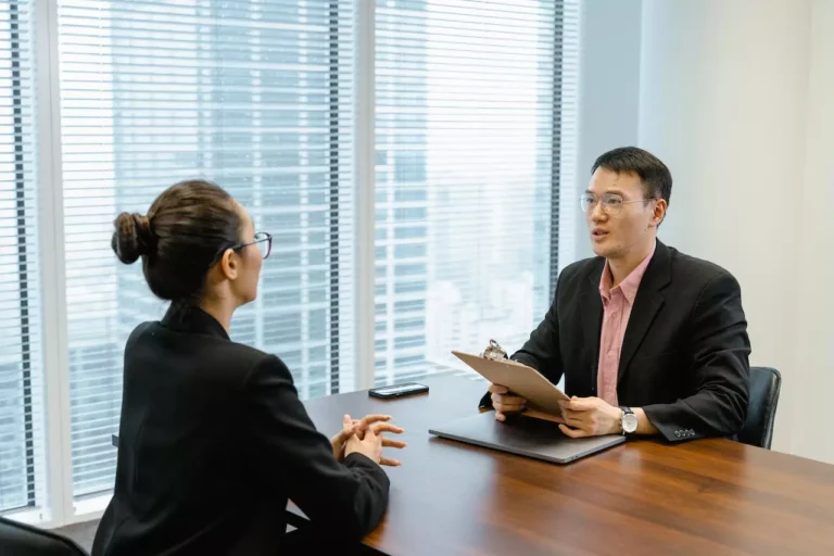 A man and woman are talking during a job interview.