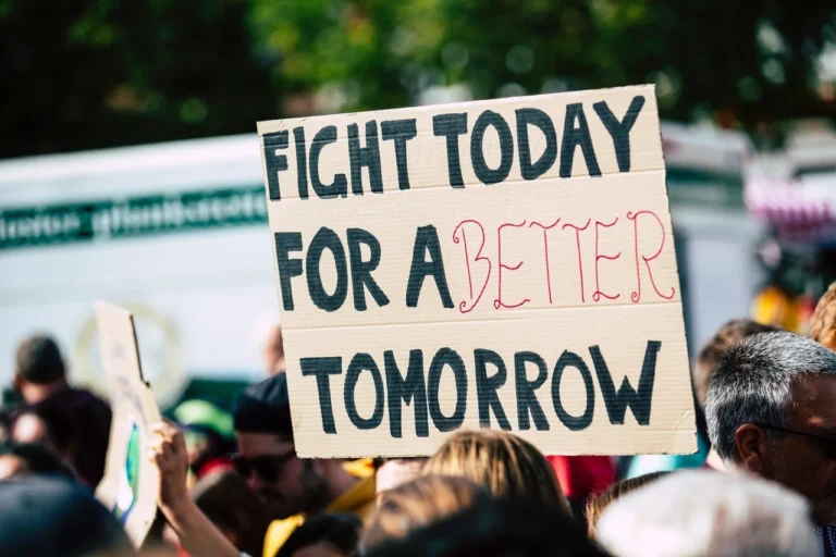 People protesting in the street with signs.